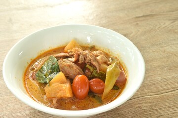 spicy boiled roasted duck meat with pineapple and tomato in coconut milk curry soup on bowl