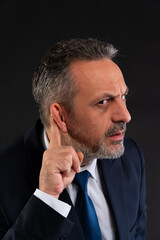 Curious businessman listening closely.