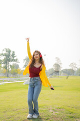 Happy Asian woman listening to music and enjoying the music dancing alone outdoors
