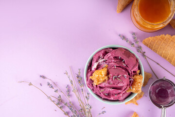 Sweet lavender honey ice cream, creamy rich taste sorbet gelato with lavender flower and syrup, honey and honeycomb. Unusual artisanal lavandula ice cream recipe idea