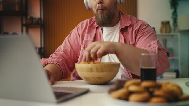 Plus-size man eating high-calorie snacks and drinking soda, diet setback