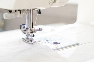 sewing machine with a cloth under a steel needle. manufacture of clothing. a household or industrial sewing machine. tailor, couturier. work on sewing designer clothes.