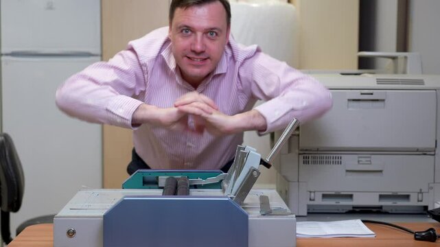 Cheerful office worker uses a paper cutter, takes a stretching break at a binding machine, and leans on the cutter in a modern office