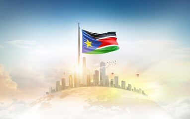 South Sudan flag wavering on globe with modern building skyline. Flag waving on world map. Sudan...