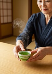 Elderly Woman Holding Steaming Green Tea Cup in Japan