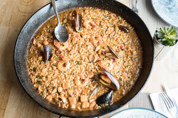 National Spanish Paella Day. Savory seafood paella with shrimp and mussels in black pan