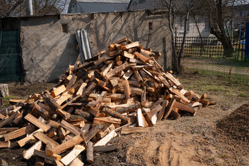 Large pile of chopped firewood outdoors in rural setting