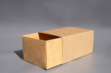 Open beige cardboard box on gray background with shadow effects