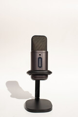 Black condenser microphone on stand with shadow