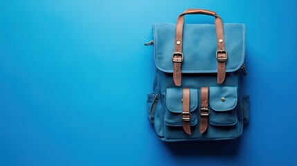 Stylish blue backpack, featuring durable canvas and brown leather accents, perfect for travel or school