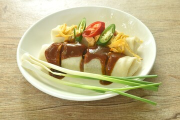 fresh Chinese spring roll made from flour wrapped tofu and pork with bean sprout dressing sweet red gravy sauce on plate   