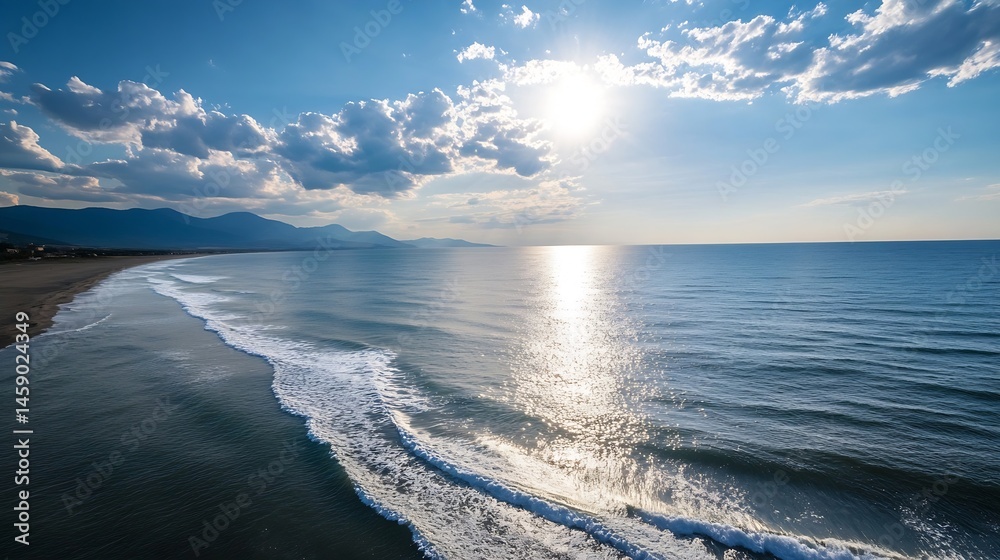 Poster aerial view of a serene coastal scene, showcasing gentle waves lapping a sandy beach under a bright,