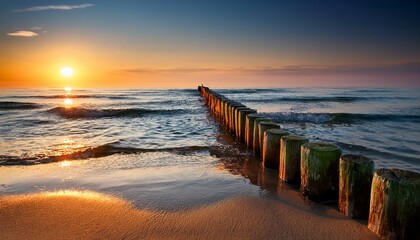 Obraz premium wooden breakwater on the beach at sunset baltic sea usedom