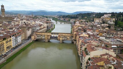 Fototapeta premium Europe, Italy, Florence , drone aerial view of Florence and Arno river - the Old Bridge , Ponte Vecchio , in city downtown of the Middle Ages and Renaissance art - Tourist attraction destination 