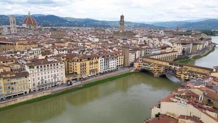 Europe, Italy, Florence , drone aerial view of Florence and Arno river - the Old Bridge , Ponte Vecchio , in city downtown  of the Middle Ages and Renaissance art - Tourist attraction destination 