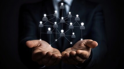A businessman holds a network of interconnected people in his hands with dark suit