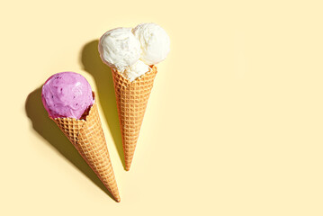 Two ice cream cones vanilla and blueberry flavors