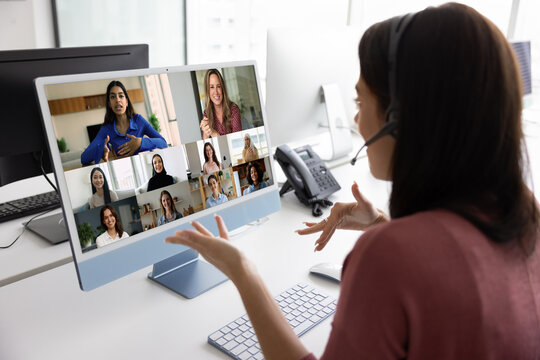 Video conference. Busy young woman coach trainer in digital headphones with mic speaking on webinar virtual event webcam group meeting with diverse multiethnic female team collaborate discuss ideas