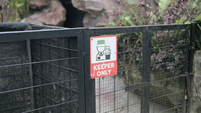 Footage of keeper only signage on animal cage at the zoo