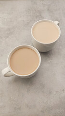 Two steaming cups of creamy coffee placed on a textured surface inviting warmth and comfort for cozy moments