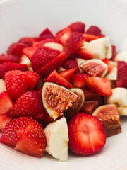 Freshly chopped strawberries and bananas in a white bowl showcasing colorful fruit medley for healthy snacking