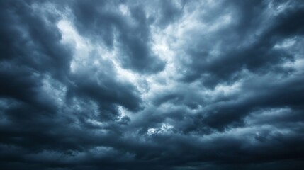 Fototapeta premium Dramatic dark cloudscape, heavy storm clouds fill the frame, moody atmospheric scene, deep blue and gray tones, ominous weather, textured sky. : Generative AI