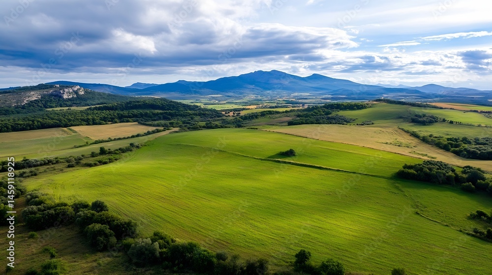 Poster Aerial view of rolling green hills and distant mountains under a partly cloudy sky, showcasing a picturesque rural landscape with fields and forests. : Generative AI