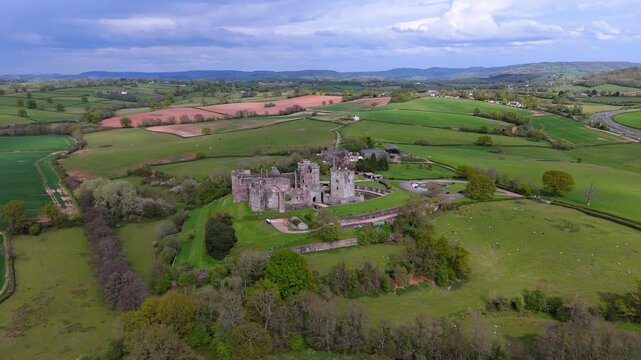 Raglan Castle ruins Wales medieval fortress aerial view farmland fields captured by drone in 4K