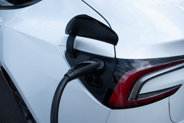 close-up electric car refueling on street charging station, Automotive industry in Europe,...