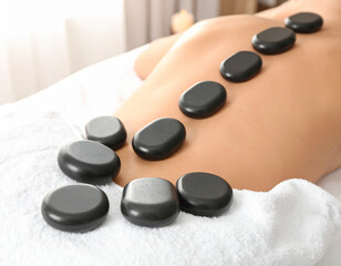 Hot stones neatly arranged on a white towel, radiating warmth under soft lighting.