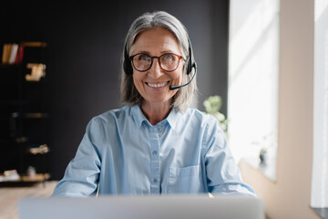 Busy mature business woman call center representative customer support agent helping client,...