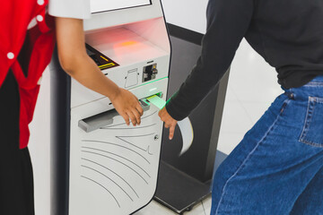 Woman traveler using self service check in machine at airport.