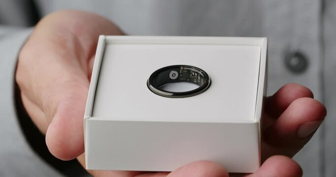Opens box with Smart Ring, Step Counter, Heart Rate, Blood Oxygen Tracker, Health Ring. Close-up. 