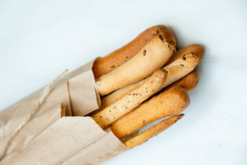 Artisan breadsticks emerge from their rustic wrapping, showcasing a golden crust and inviting aroma