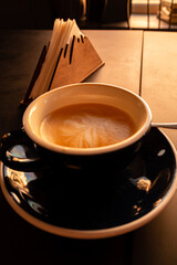 Delicious coffee swirls in a dark cup, capturing the warm light of the evening