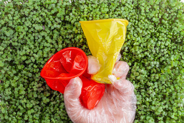 Plastic waste against a background of green plants - environmental pollution