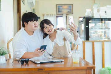Obraz premium Asian couple enjoying activity together lifestyle taking selfie with smartphone at home smiling happy