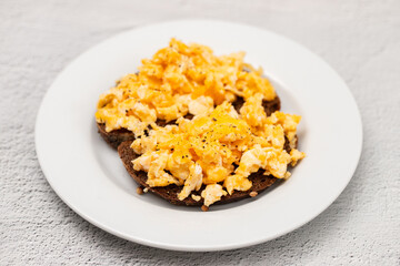 scramble eggs with black bread on dish