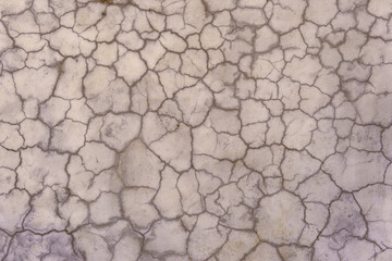 Cracks in the plaster covering the old gray wall. Abstract construction background.