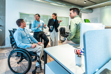 Diverse businesspeople discussing during meeting in modern office with disabled colleague