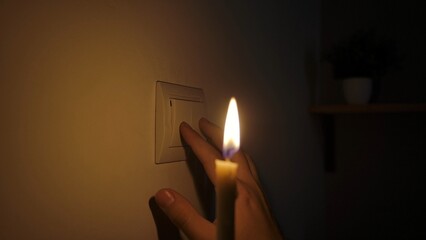 Hand Approaching Light Switch During Power Outage