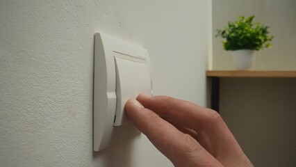 Person Switching Off Electric Light Using Wall Switch