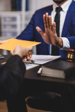 Honest officials refuse bribes. Lawyer refusing a bribe from a businessman in his office, he is pushing back the envelope with his hand.
