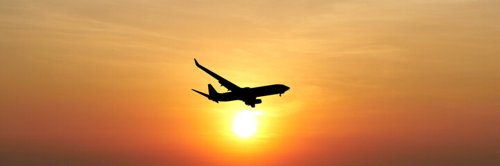 Silhouette Flight: An airplane soaring gracefully against a vibrant backdrop of a sunset, its dark form creating a striking contrast against the warm hues of the sky.