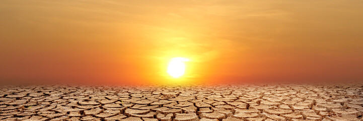 Arid Sunset: Capturing the stark beauty of a drought-stricken landscape at sunset, with a blazing...