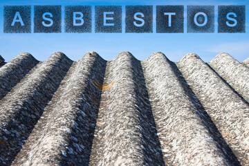 Aged dangerous asbestos roof made of prefabricated corrugated panels with asbestos text