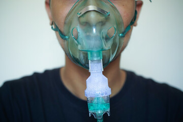 Close up Young man using nebulizer for asthma and respiratory diseases at home