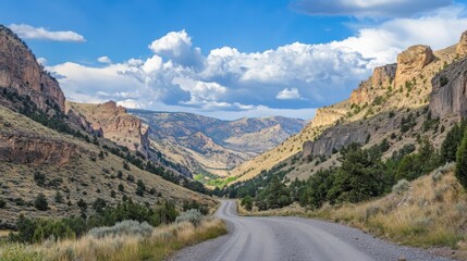 Fototapeta premium Isolated American road heading through a high-altitude valley surrounded by mountains and sky