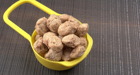 Raw soya chunks on dark background. Healthy, nutritious soybean meat, chunks isolated.Vegan food concept.