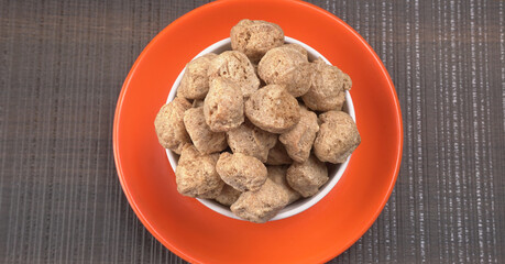 Raw soya chunks on dark background. Healthy, nutritious soybean meat, chunks isolated.Vegan food concept.